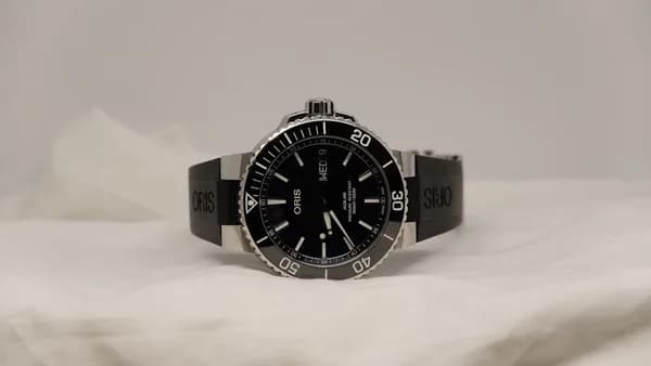 a watch sitting on top of a white sheet