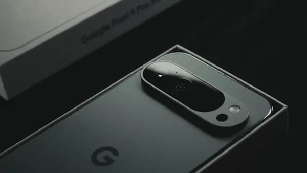 A close up of a cell phone near a laptop