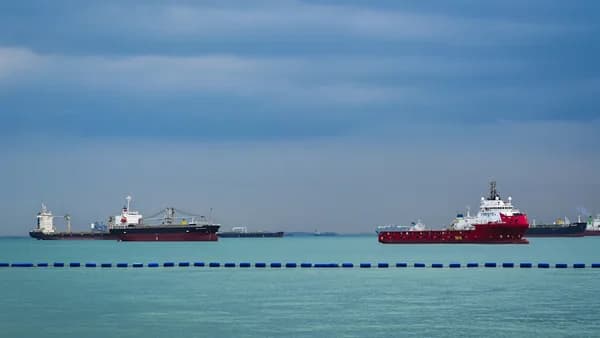 three large ships in the ocean with a sky background