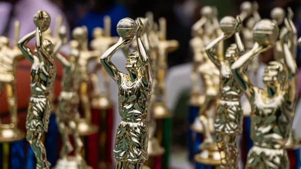 Rows of golden trophies displayed at an event