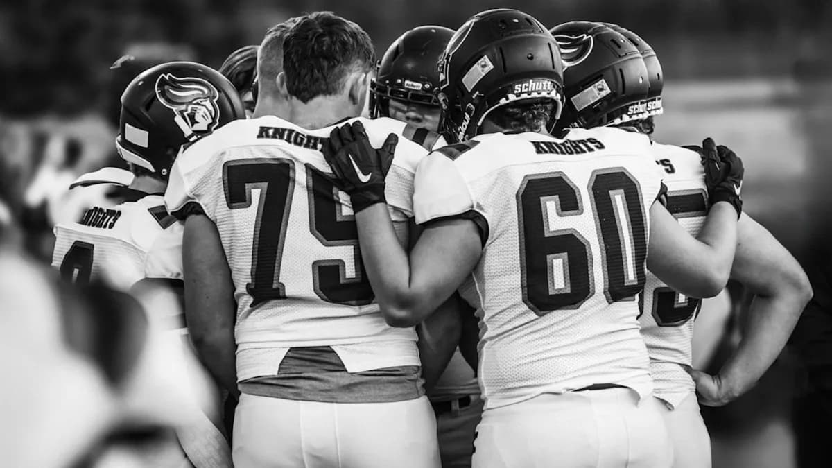American football players huddle together before a game.