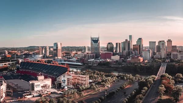 American football arena beside building and roadway during daytime