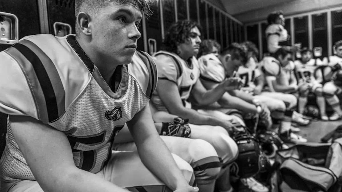 Football players sitting in a locker room