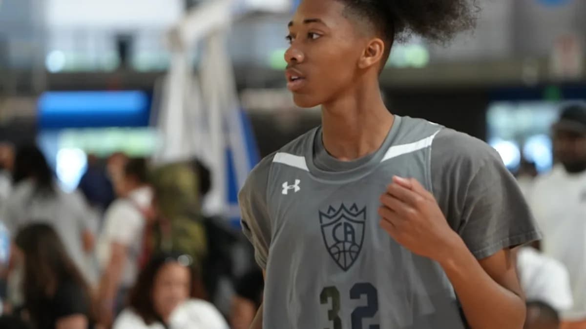 a woman in a gray jersey running in a crowd