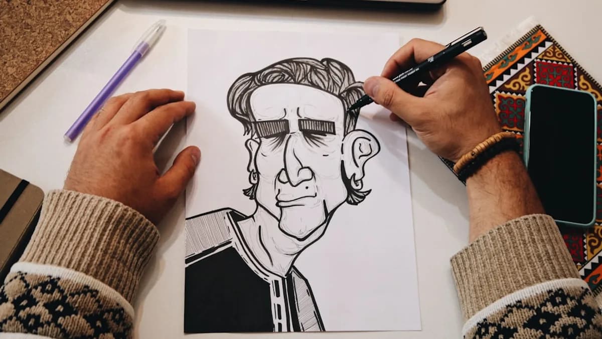 person holding pen drawing on white paper