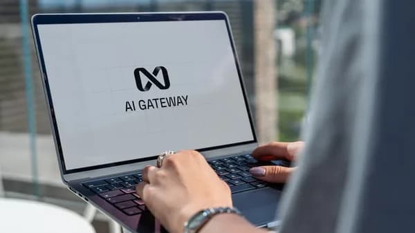 Person typing on laptop with ai gateway logo.
