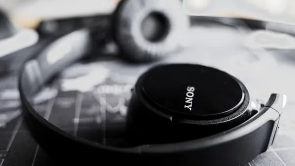 Black sony headphones resting on a surface.
