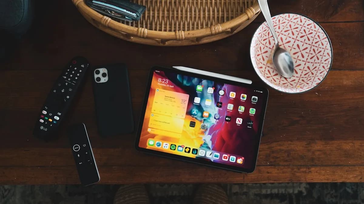 black iphone 5 beside black remote control on brown wooden table