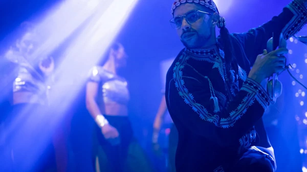 a man standing on a stage holding a guitar