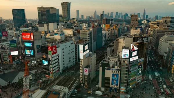 Busy cityscape with tall buildings and bright billboards.
