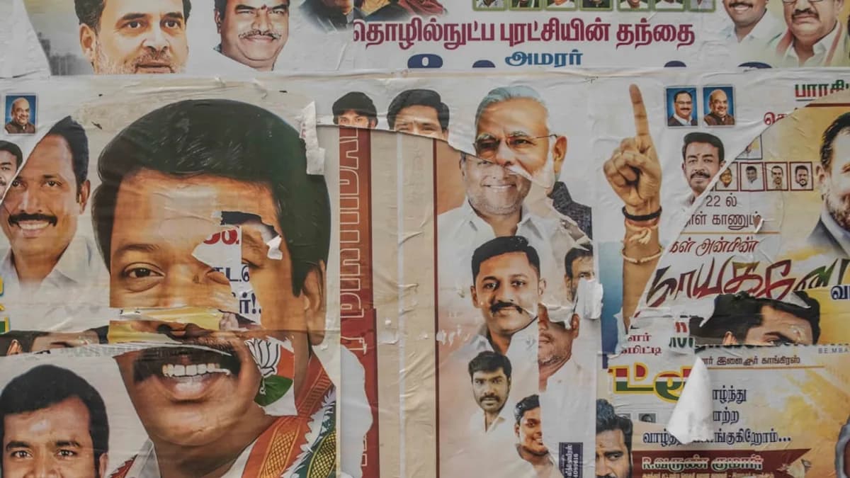 Political posters are plastered on a wall.