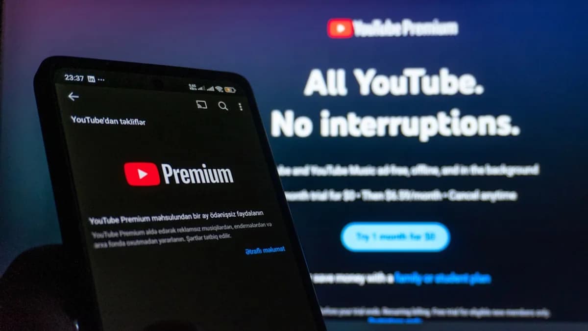 Smartphone displaying youtube premium next to TV screen.