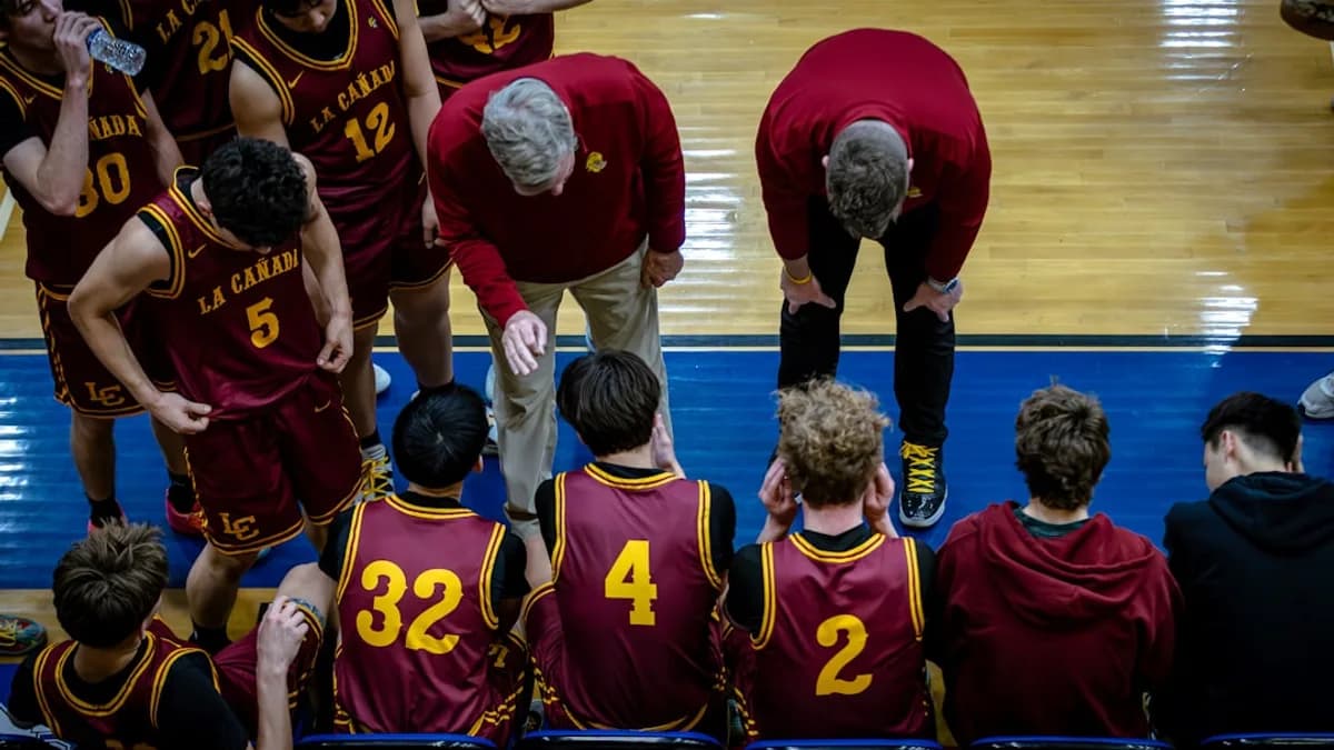 Basketball team listening to coaches during a timeout.