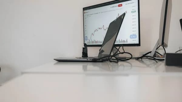 a desk with a laptop and a monitor on it