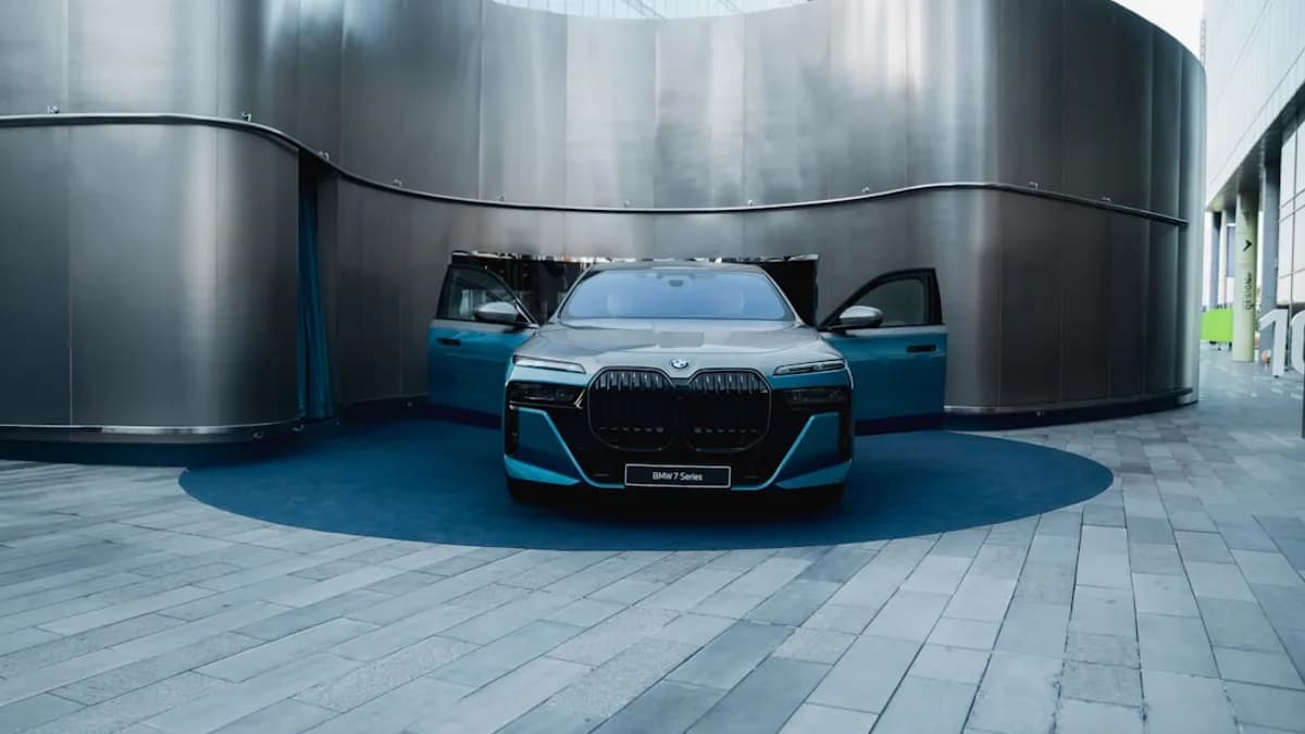 Modern teal car with doors open in architectural space