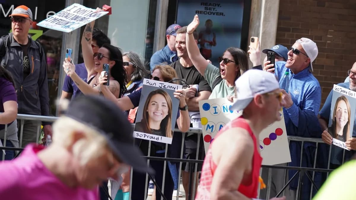 a group of people holding up signs in front of a fence
