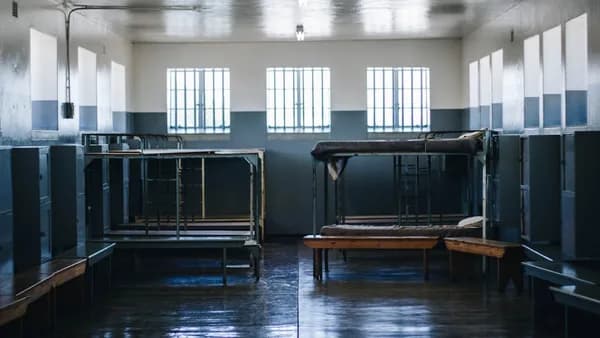 woman in gray shirt with left hand on her chin