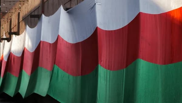 A train traveling down train tracks next to a bridge