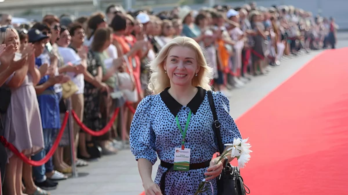 a woman is walking down a red carpet