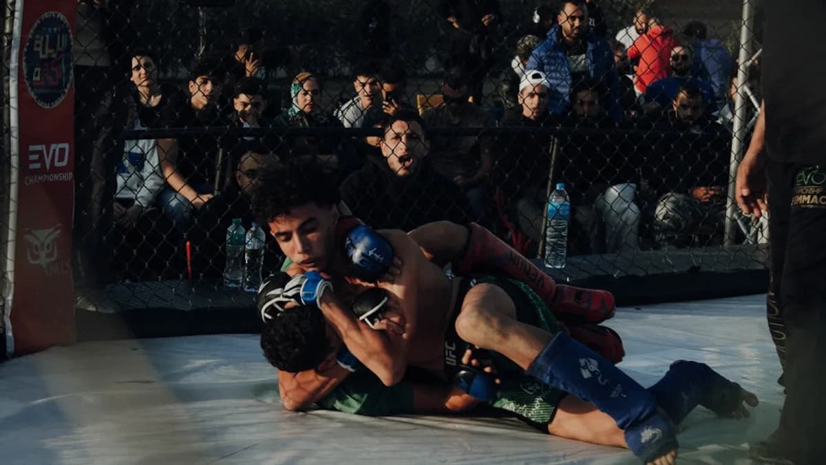 A group of people standing around a wrestling ring