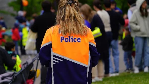 A person wearing a police jacket in a crowd