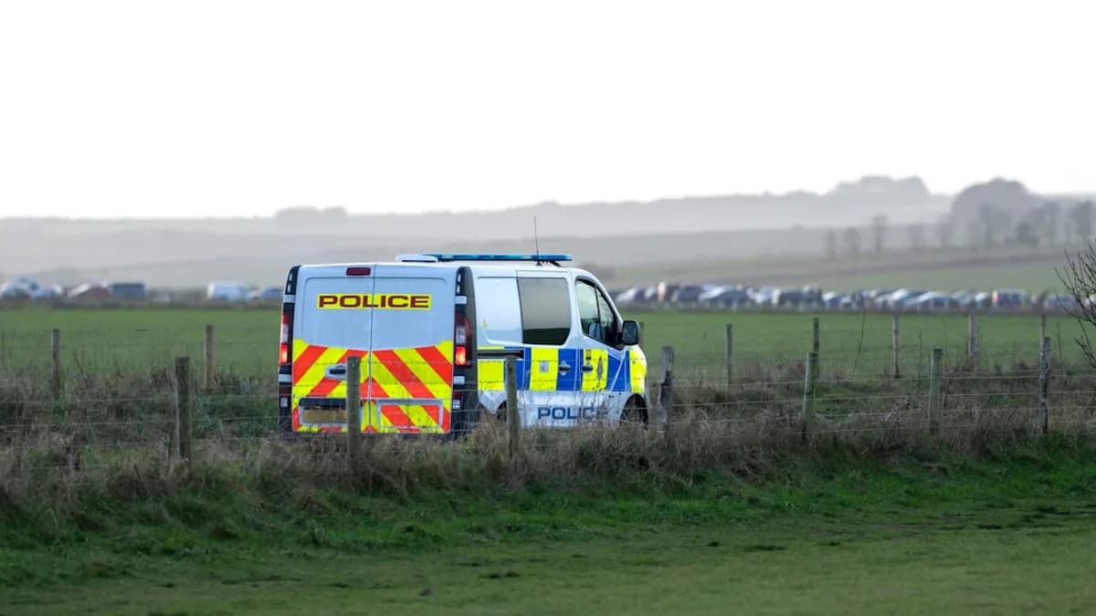 a police van parked in a field behind a fence
