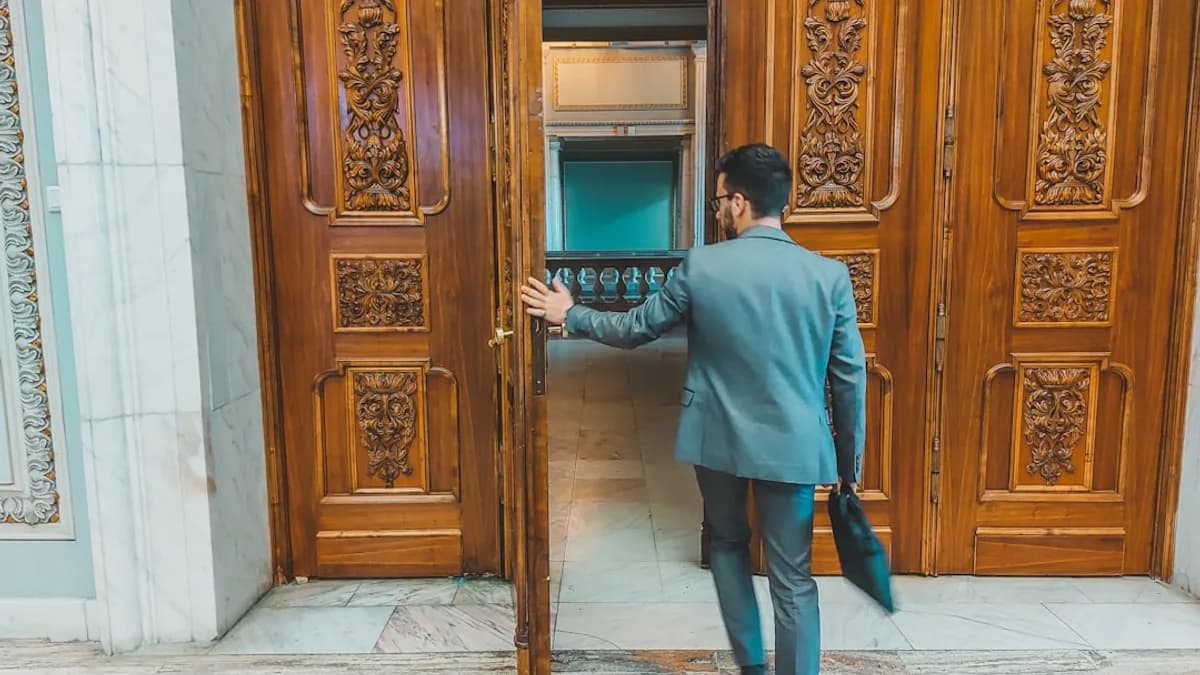 a man in a suit is entering a building