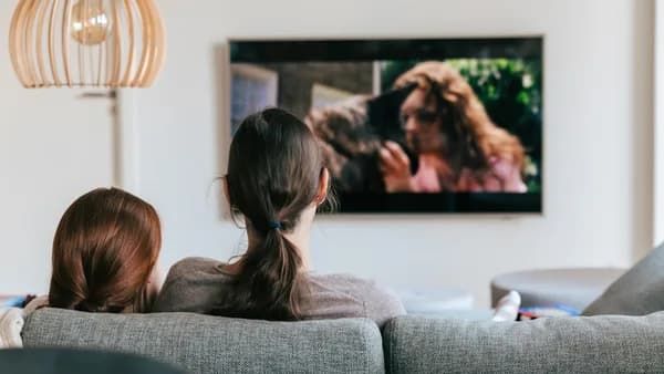 a couple of women sitting on top of a couch