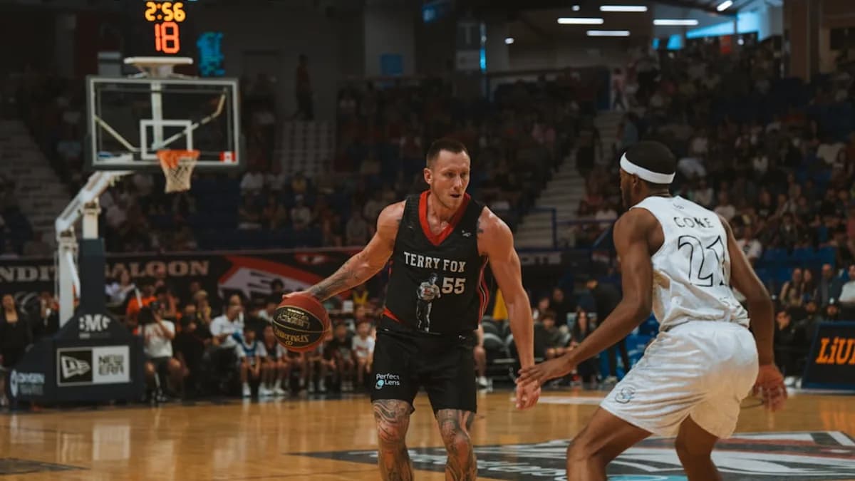 A basketball player dribbles the ball on the court.