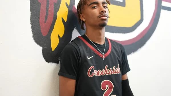 a man standing in front of a wall with a painting on it