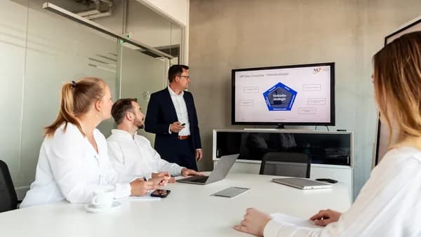 Business meeting with a presenter and colleagues in office.