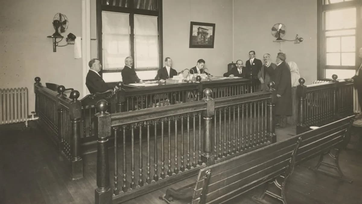 a group of men standing around a wooden desk