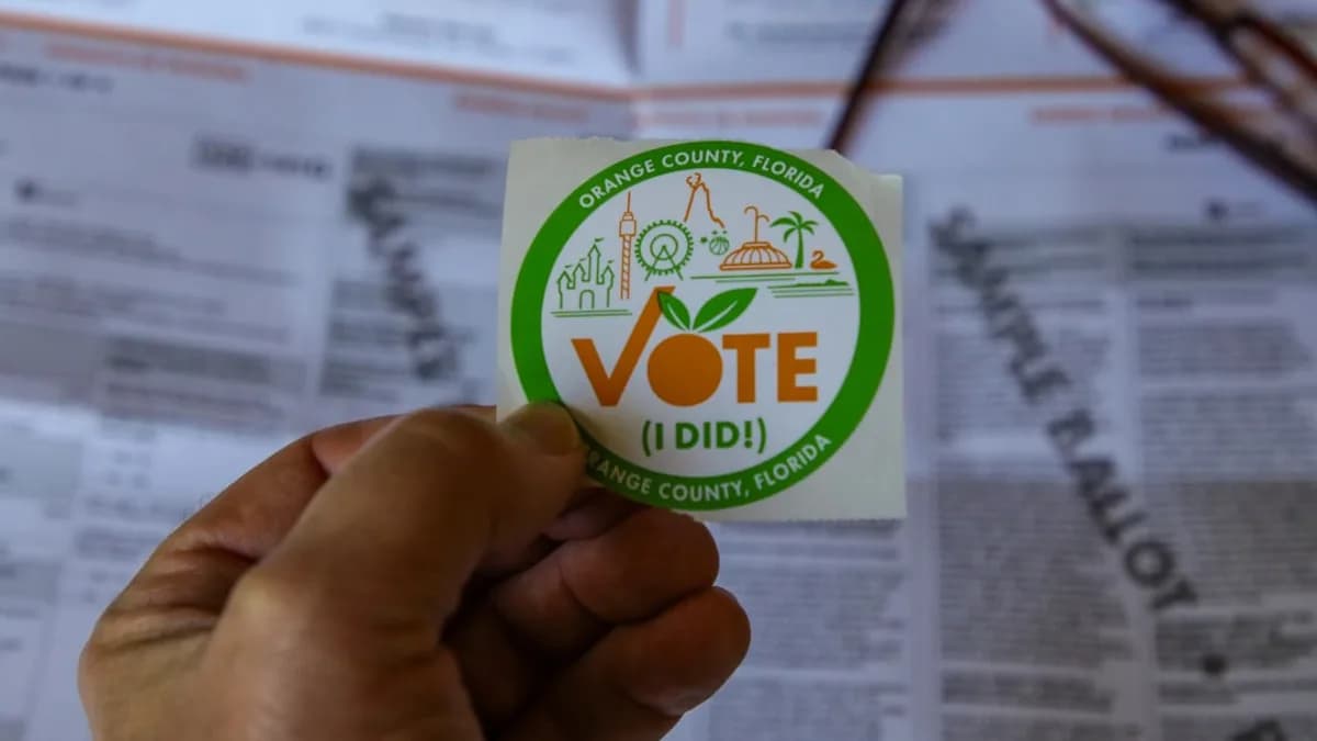 a hand holding a sticker that says vote ididi