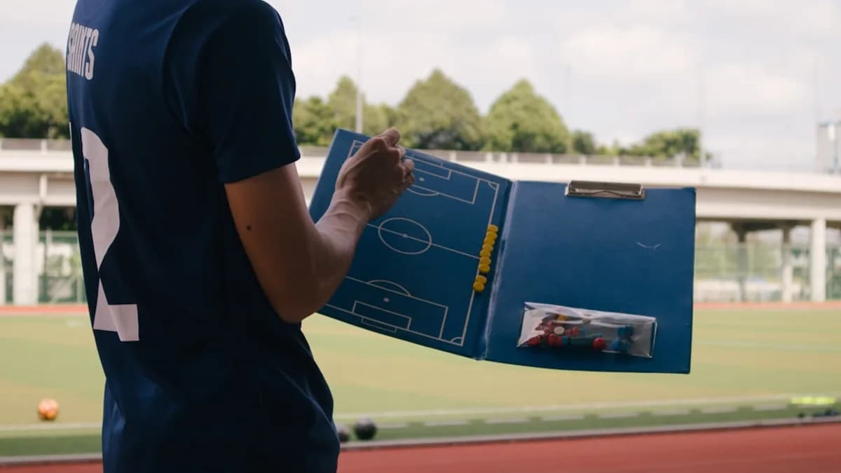 man in blue crew neck t-shirt standing on track field during daytime
