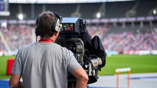 a man with headphones on sitting in front of a camera