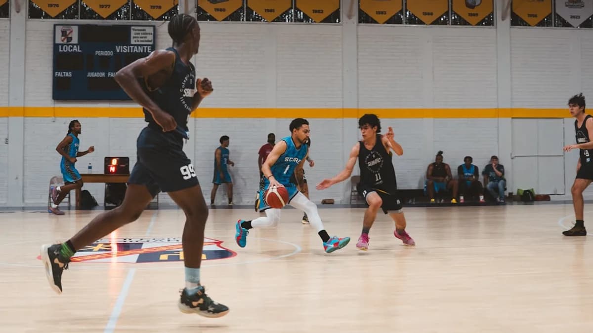 Basketball players dribbling and running on court.