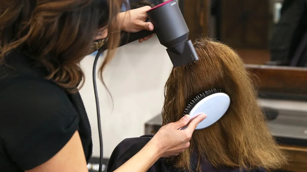woman holding white and black hair blower
