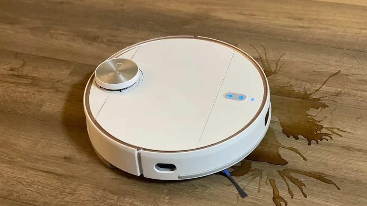 a white robot vacuum on a wooden floor