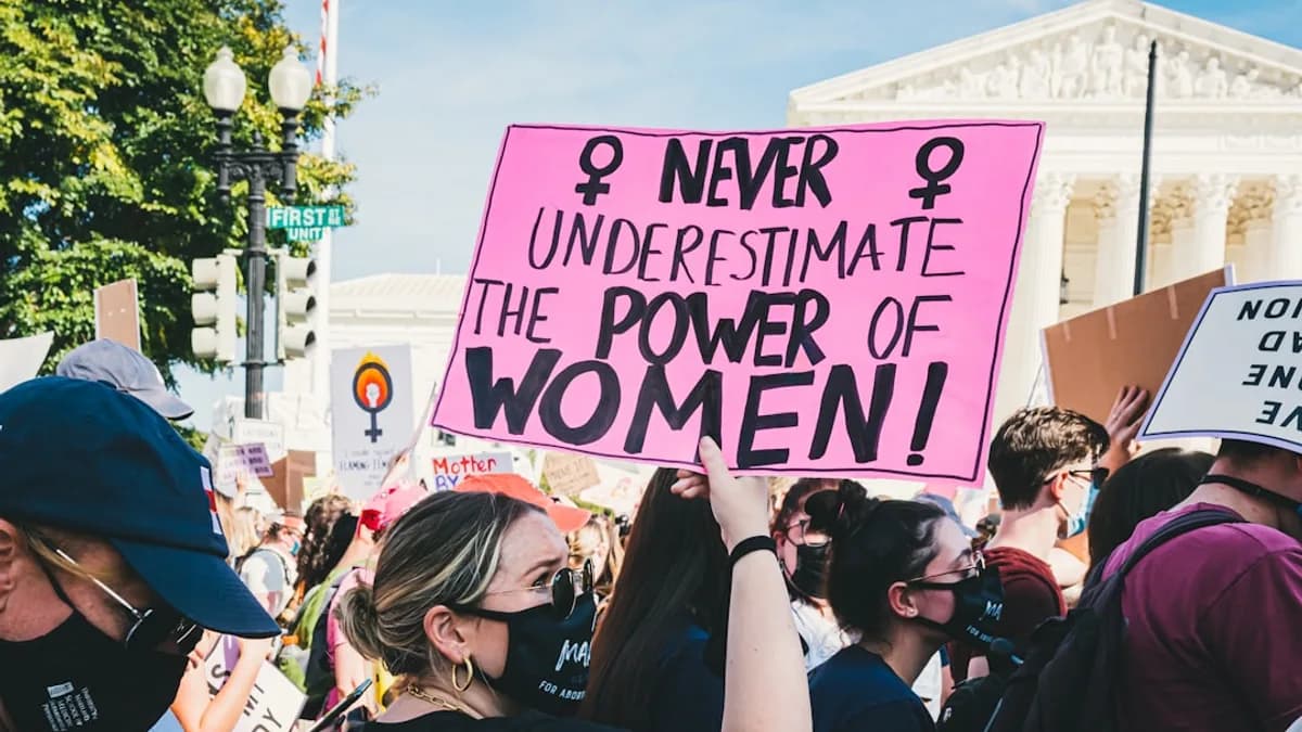 a group of people holding signs and wearing masks