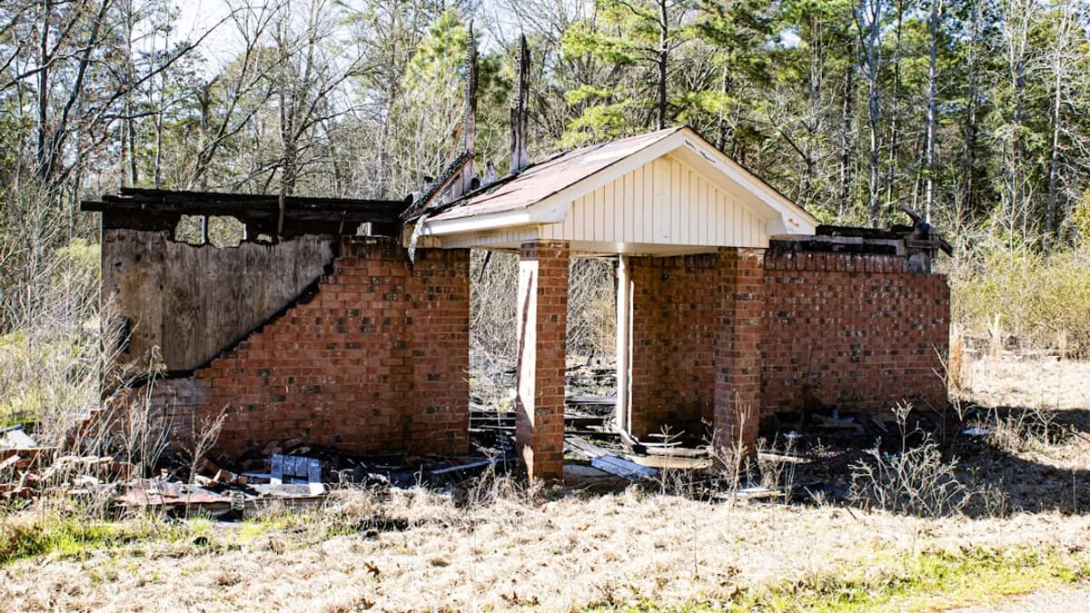 A damaged brick structure stands ruined.
