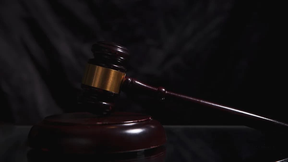 A wooden gavel rests on a dark surface.