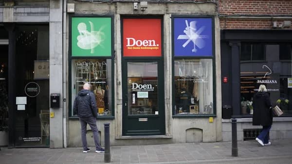 A shopfront with colorful signage and people.