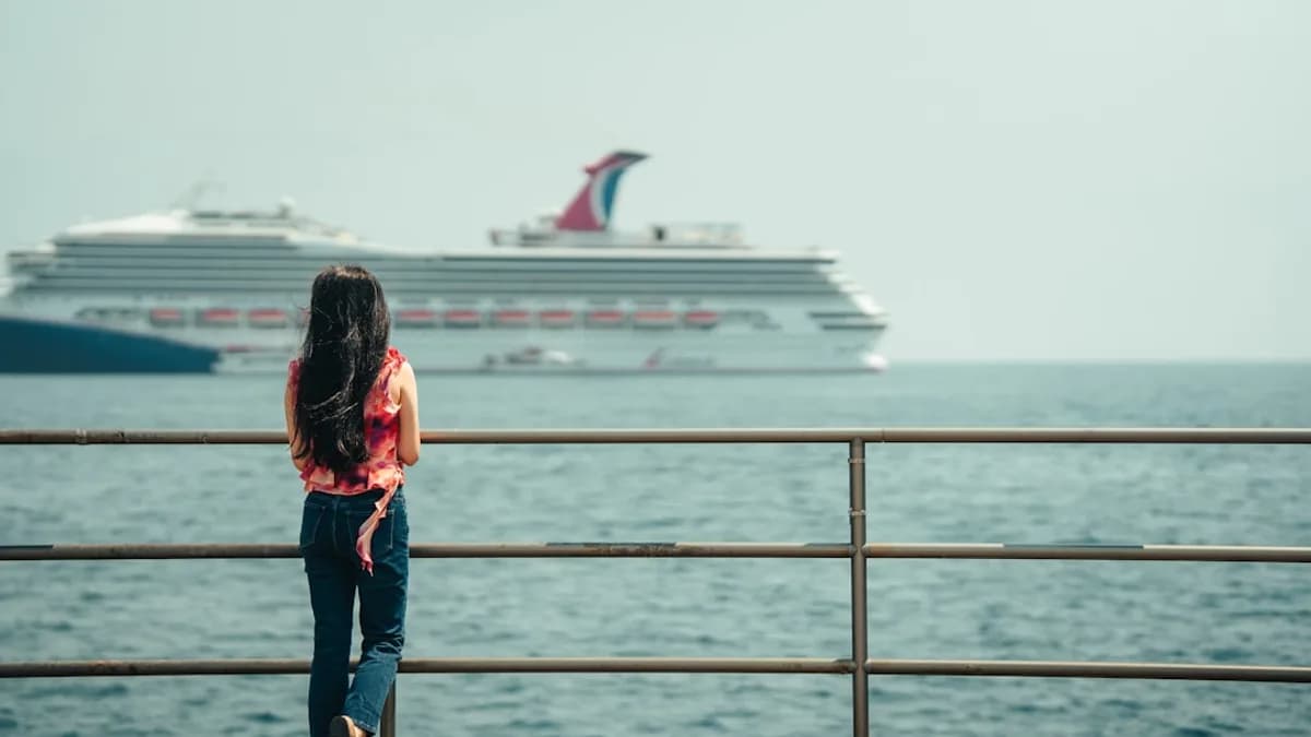 Woman watches a large cruise ship on the ocean.
