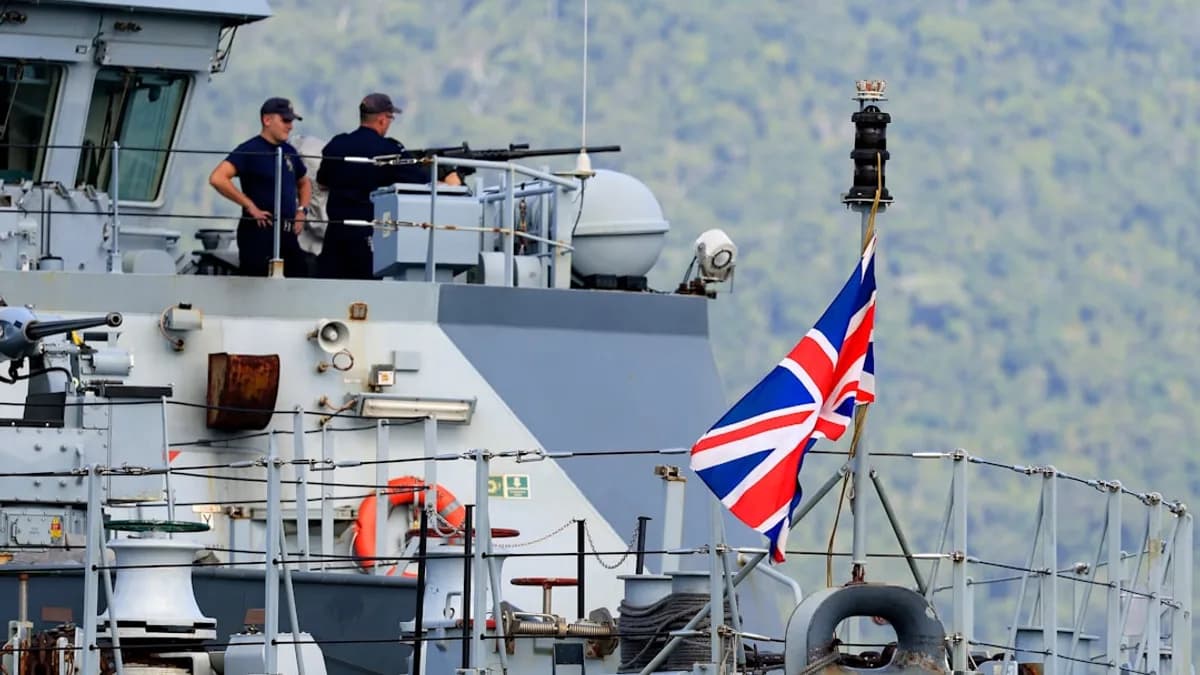 two men standing on top of a boat with a flag