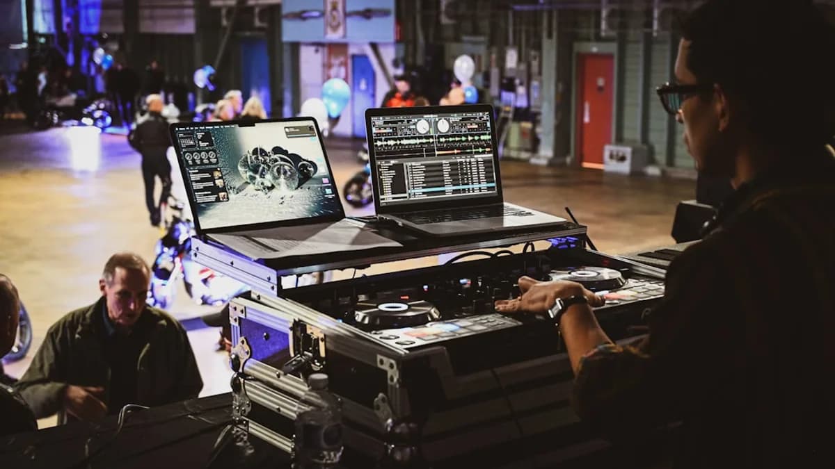 Dj performing with laptops and equipment at event