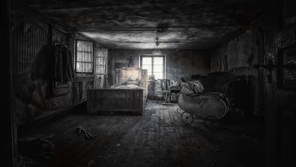 a dark room with a bed and a rocking chair
