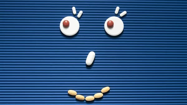 A sad face made out of pills on a blue background