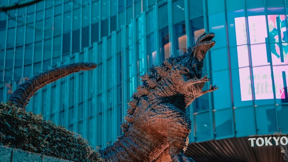 Godzilla statue in front of a building in tokyo.