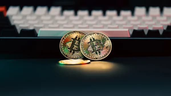 Two bitcoins sitting next to a computer keyboard