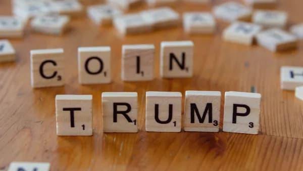 Scrabble letters spelling the word coin trump on a wooden table